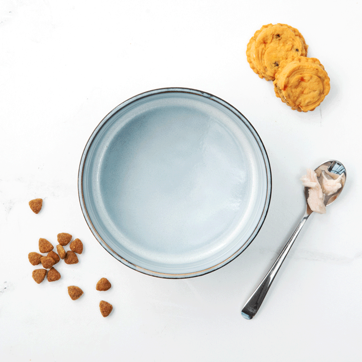 Steps to prepare Savory Salmon & Chicken &Eacute;touff&eacute;e Recipe by combining BLUE Life Protection Formula Chicken & Brown Rice Recipe dry dog food, BLUE Salmon & Chicken Tender Shreds dog food topper, and BLUE Homestyle Nudges Chicken Pot Pie Recipe dog treat- Bowl of cookies and a spoon are arranged on a clean white surface, creating an appealing snack preparation.