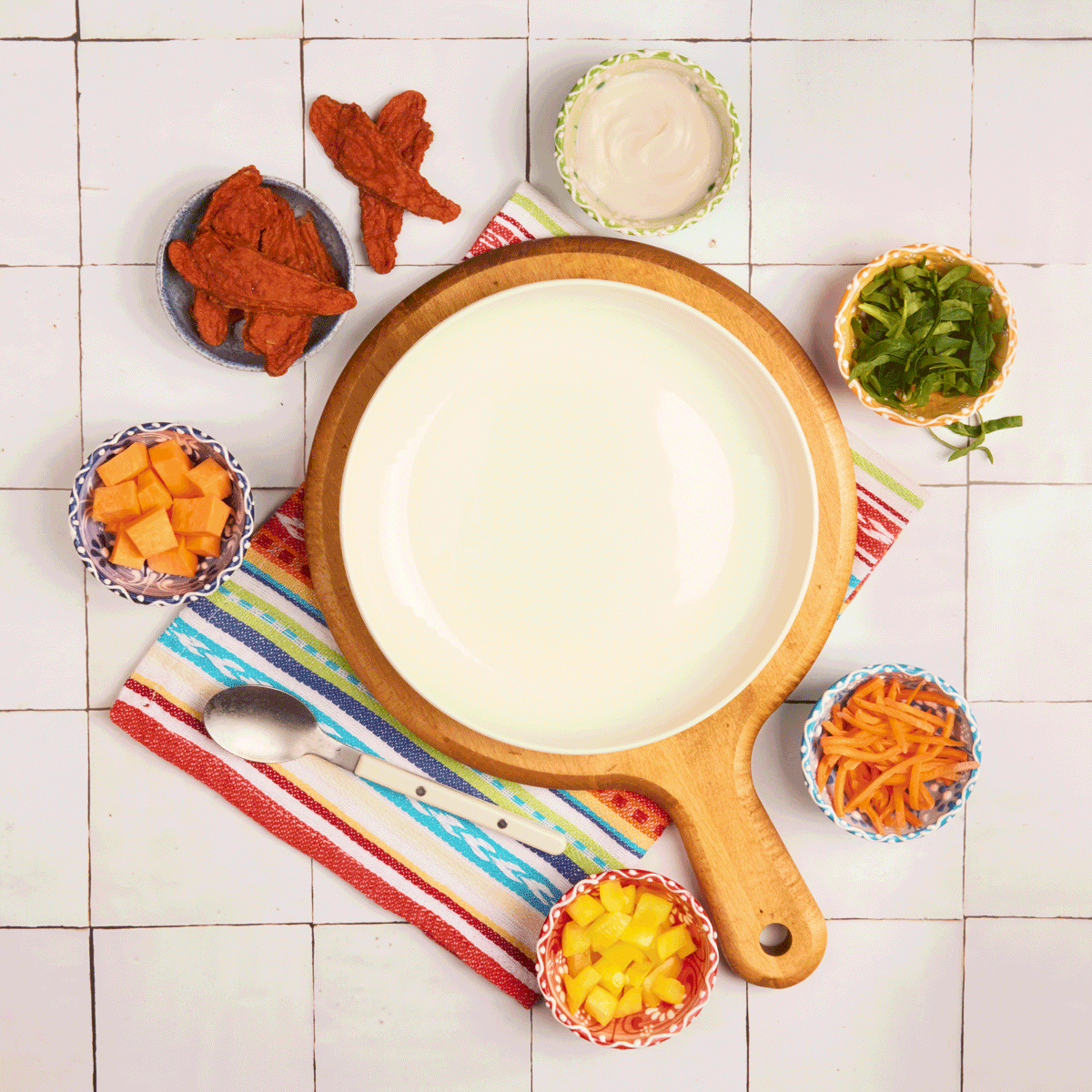 Animated gif of a taco bowl being assembled with veggies, cheese, chicken strips, and dressing.