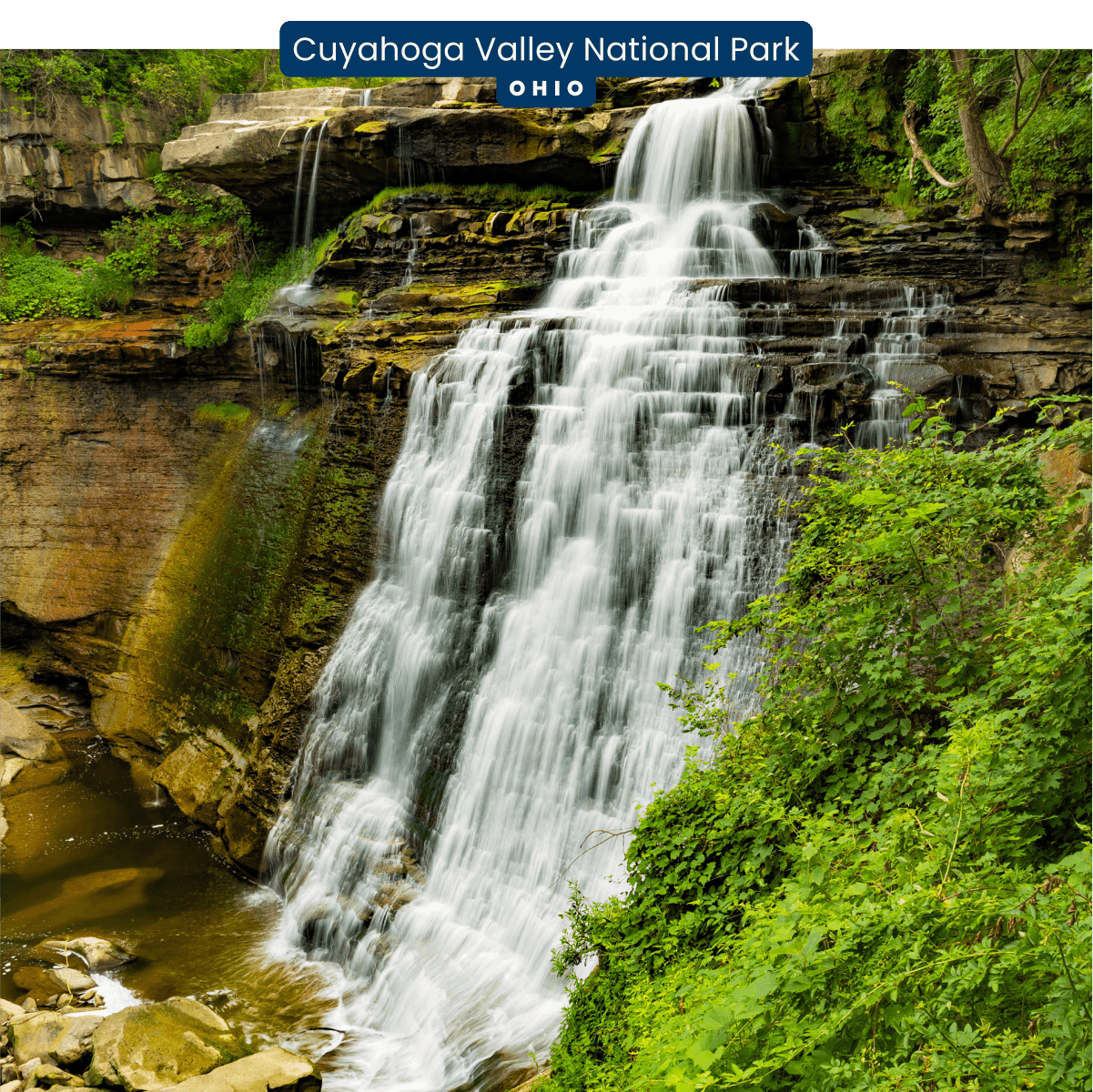 A tall waterfall pours down the side of a rocky, but very lush cliff in Cuyahoga Valley National Park, Ohio.